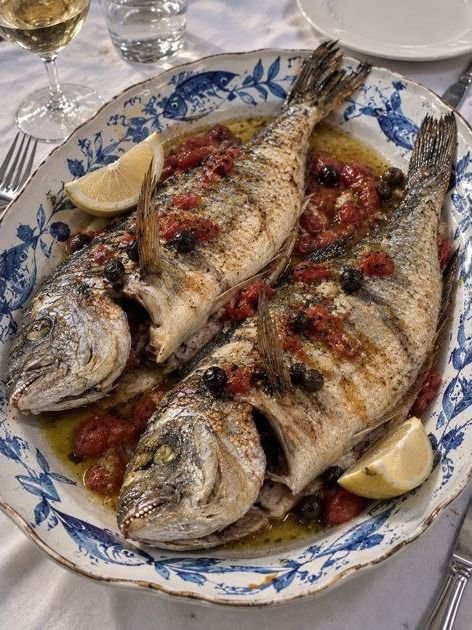 Orata al forno con pomodorini in un piatto decorato